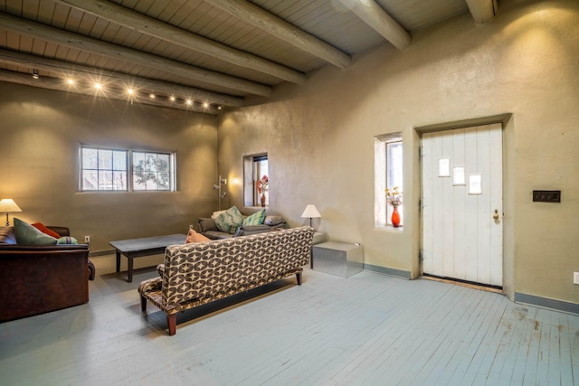 living area with wooden ceiling, beamed ceiling, baseboards, and wood-type flooring