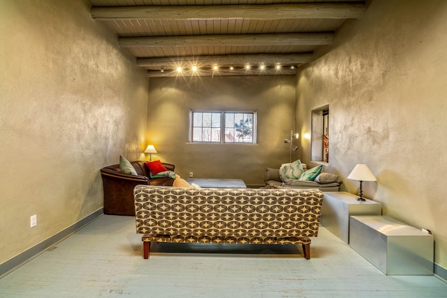 sitting room with wooden ceiling, beamed ceiling, wood finished floors, and baseboards