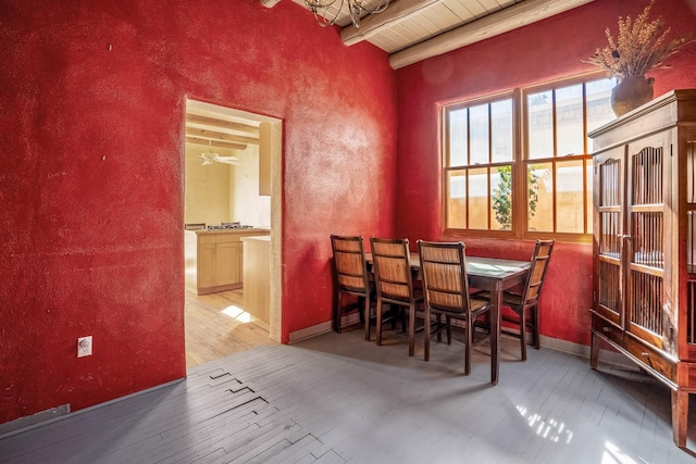 dining room featuring beamed ceiling, wood ceiling, baseboards, and wood-type flooring