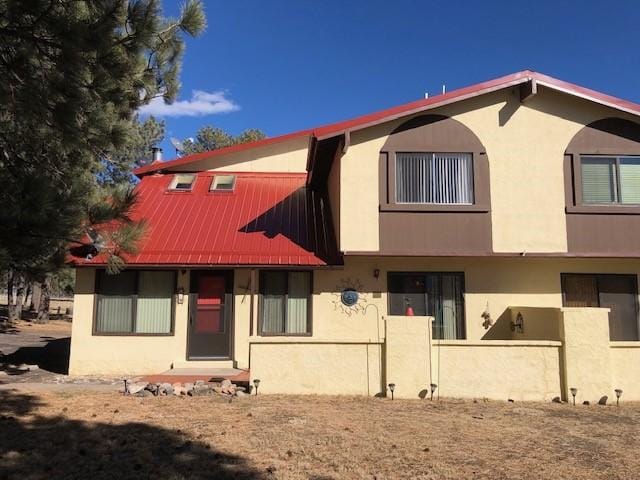 view of front of home with stucco siding and metal roof