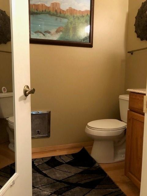 half bath with toilet, vanity, and baseboards