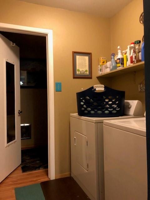 laundry room featuring laundry area, washing machine and dryer, and wood finished floors