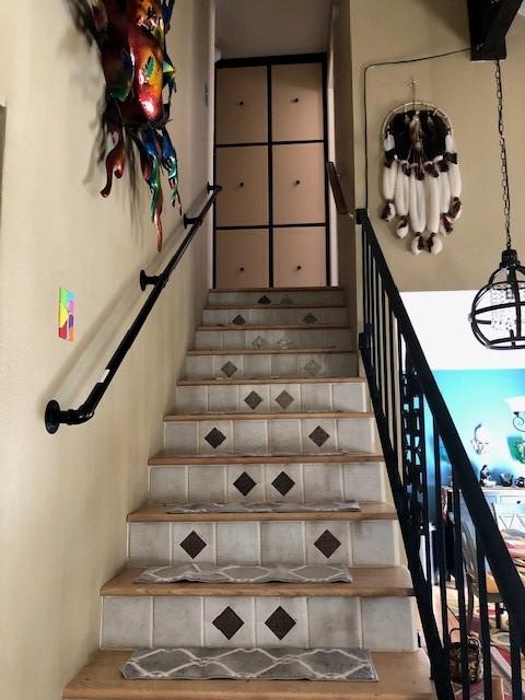 staircase with an inviting chandelier