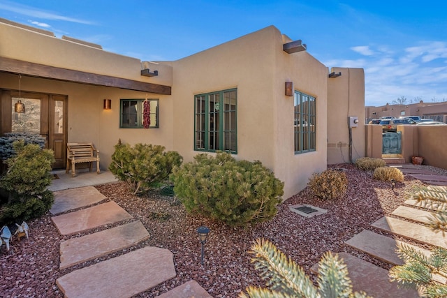 exterior space featuring a gate and stucco siding