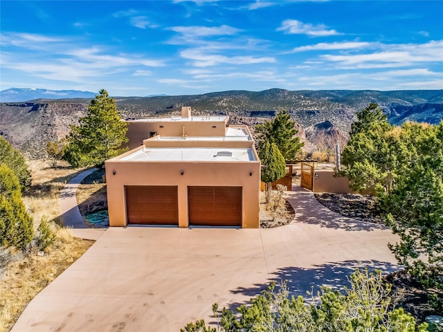 view of front of house with a garage, a mountain view, and stucco siding