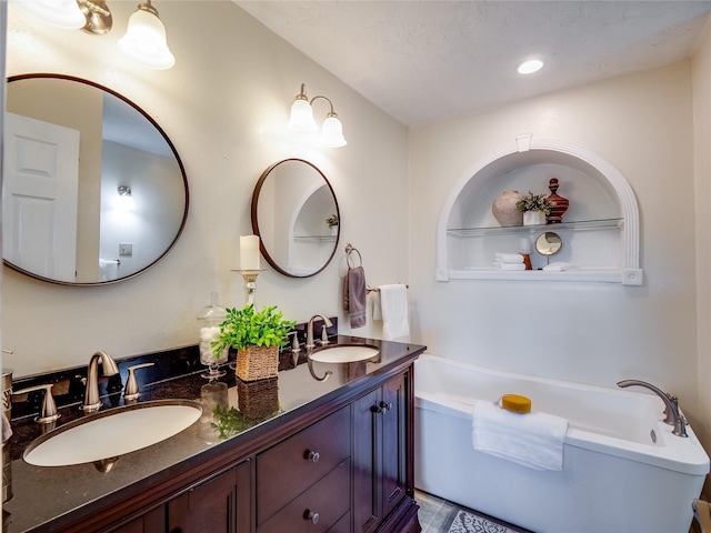 full bathroom featuring double vanity, recessed lighting, a bath, and a sink