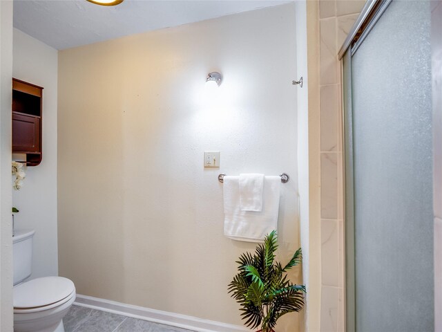 full bathroom featuring tile patterned flooring, an enclosed shower, toilet, and baseboards