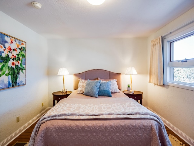 bedroom with baseboards and wood finished floors