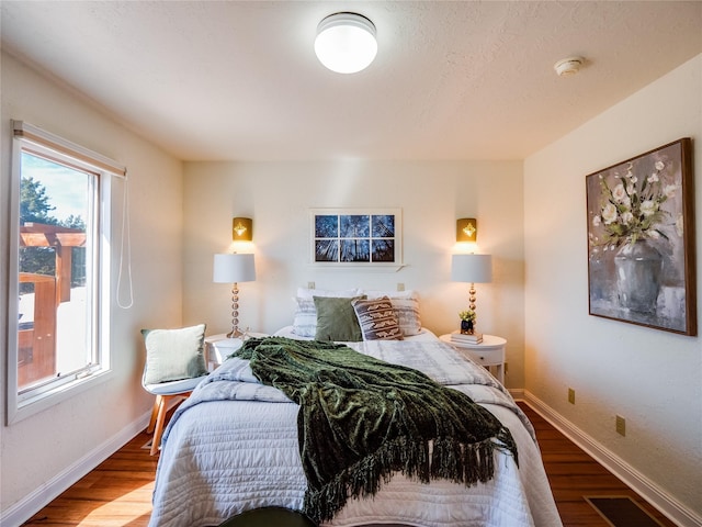 bedroom featuring visible vents, baseboards, and wood finished floors