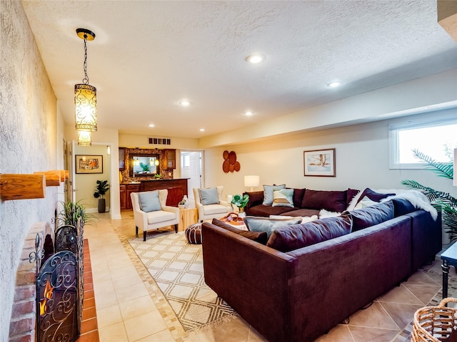 living room featuring recessed lighting, visible vents, a textured ceiling, and light tile patterned floors