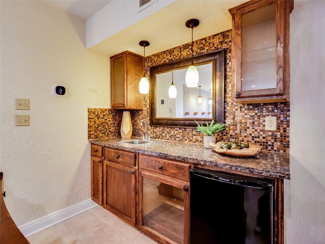 kitchen featuring decorative light fixtures, brown cabinets, backsplash, and black dishwasher