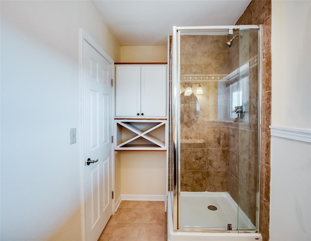 full bath featuring tile patterned flooring, a stall shower, baseboards, and a closet