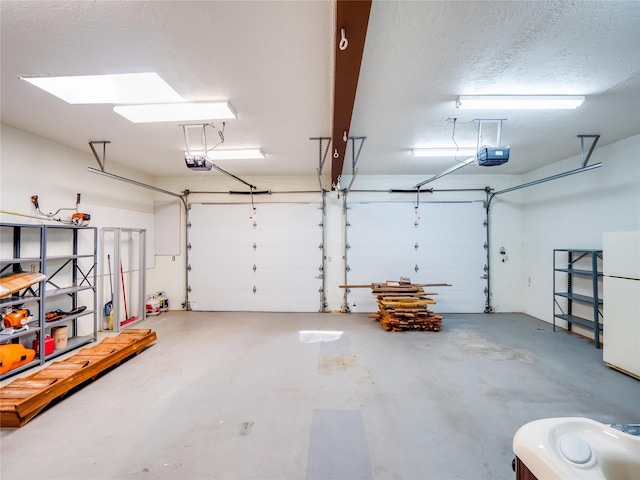 garage featuring a garage door opener and freestanding refrigerator