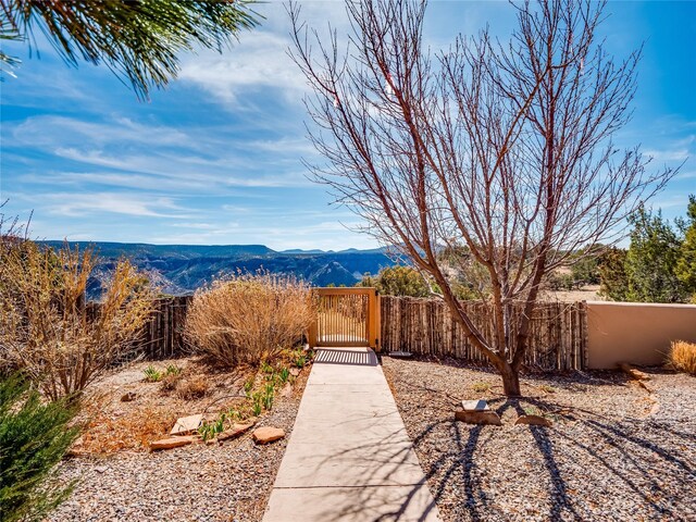 view of yard featuring a gate, fence, and a mountain view