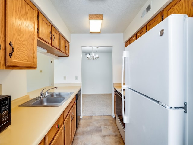 kitchen featuring visible vents, light countertops, brown cabinets, black appliances, and a sink