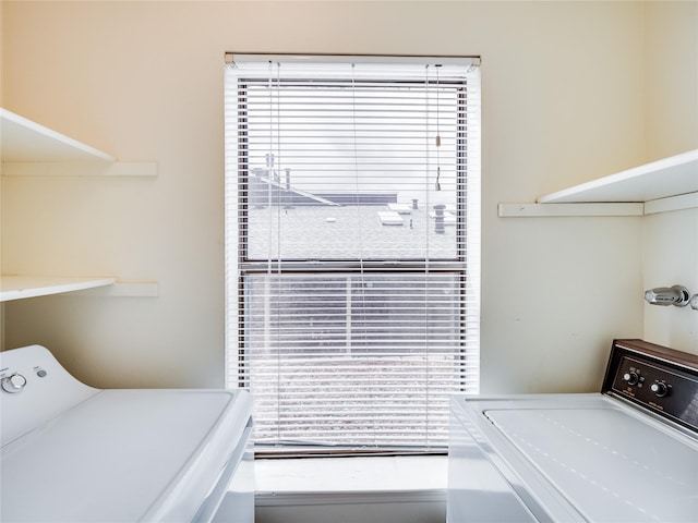 laundry room featuring a wealth of natural light, laundry area, and washer and clothes dryer