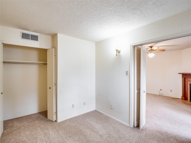 unfurnished bedroom with carpet flooring, visible vents, and a tile fireplace