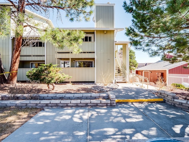 back of property with stairway, a chimney, and fence