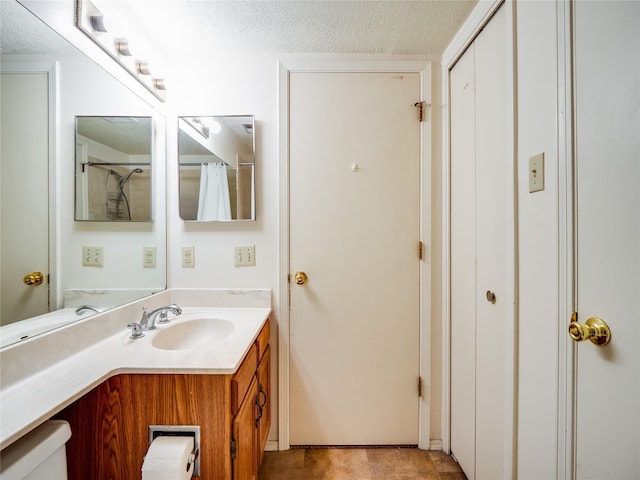 full bathroom featuring a shower with curtain, a textured ceiling, and vanity