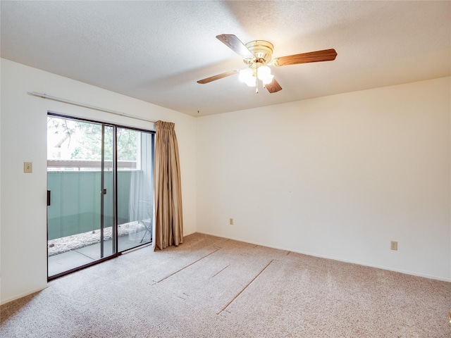 empty room with ceiling fan, light colored carpet, and a textured ceiling