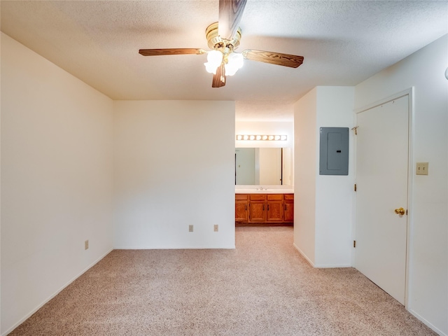 unfurnished bedroom featuring a sink, electric panel, light colored carpet, and a textured ceiling