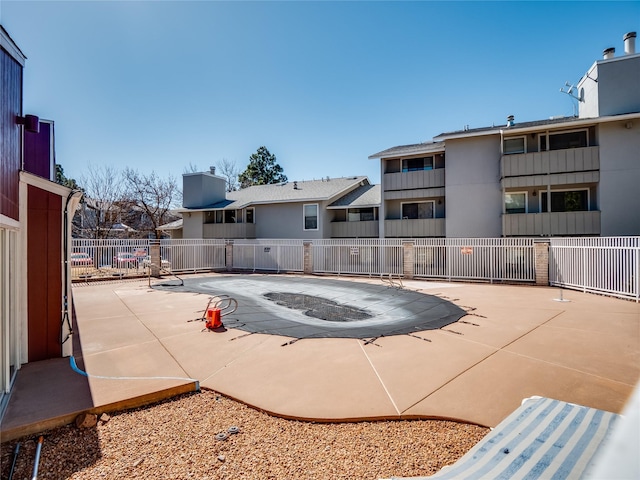 pool with a patio and fence