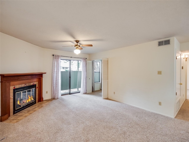 unfurnished living room with visible vents, light carpet, a ceiling fan, a fireplace, and baseboards