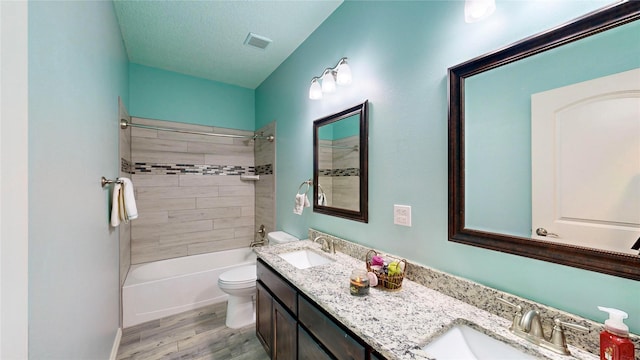 bathroom featuring toilet, wood finished floors, visible vents, and a sink