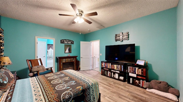 bedroom featuring a textured ceiling, ceiling fan, and wood finished floors