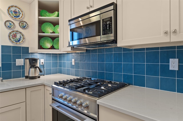 3101 Old Pecos Trl Unit 219, Santa Fe, NM 87505 - kitchen with white cabinetry, open shelves, stainless steel appliances, light stone countertops, and backsplash