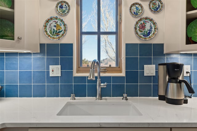 3101 Old Pecos Trl Unit 219, Santa Fe, NM 87505 - interior space with light stone counters, backsplash, glass insert cabinets, and a sink