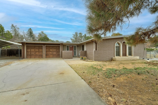 ranch-style home featuring brick siding, concrete driveway, a garage, and fence