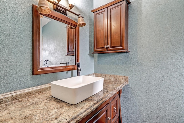 bathroom with vanity and a textured wall