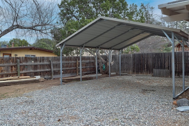 exterior space with a carport, driveway, and fence