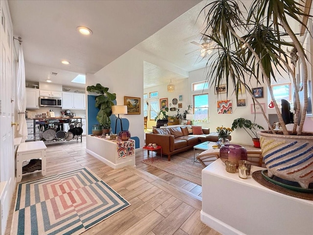 living area featuring recessed lighting, baseboards, and light wood finished floors