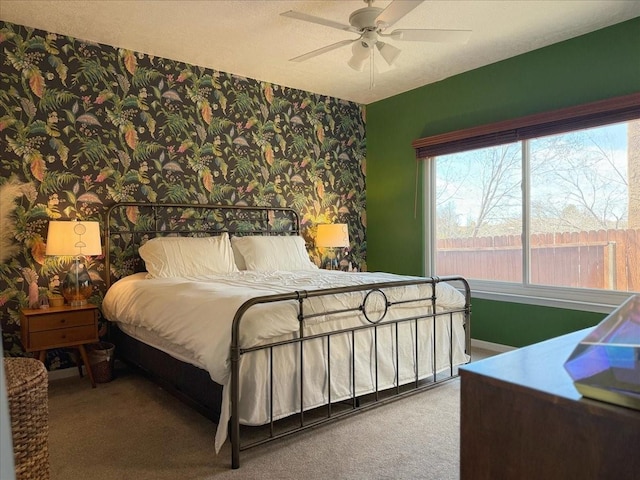 bedroom featuring a textured ceiling, carpet, a ceiling fan, and wallpapered walls