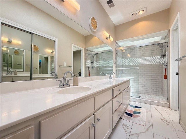 full bathroom featuring visible vents, double vanity, a stall shower, a sink, and marble finish floor