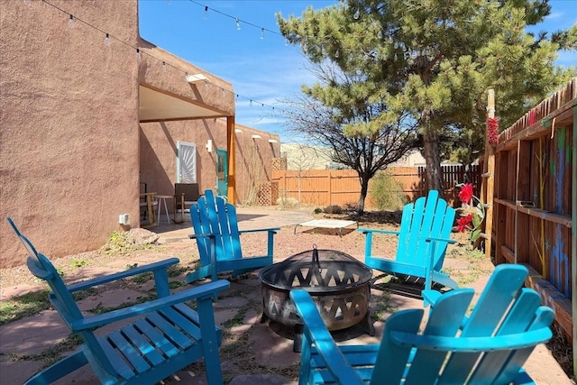 view of yard with a patio, a fenced backyard, and an outdoor fire pit