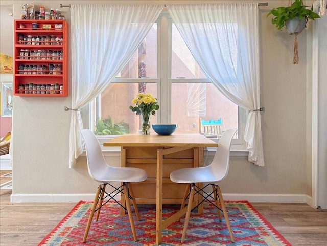 dining space featuring a wealth of natural light, baseboards, and wood finished floors