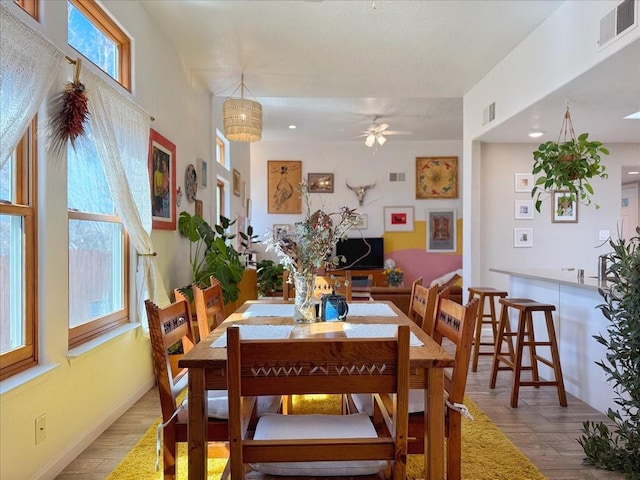 dining area with visible vents, ceiling fan, baseboards, and wood finished floors