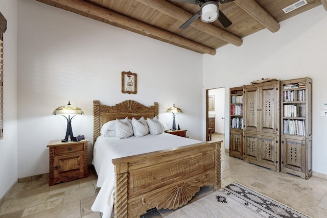 bedroom featuring visible vents, beam ceiling, ensuite bathroom, stone finish floor, and wood ceiling