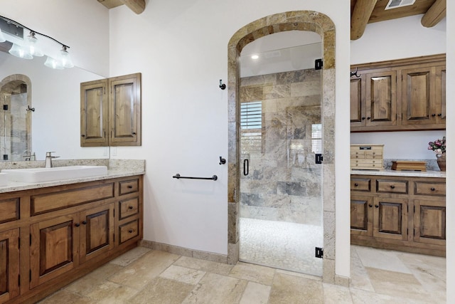 bathroom featuring vanity, visible vents, baseboards, and a stall shower