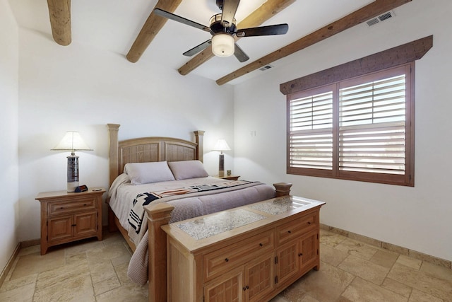 bedroom featuring baseboards, visible vents, beam ceiling, and stone tile floors