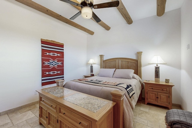 bedroom featuring stone tile floors, beam ceiling, a ceiling fan, and baseboards