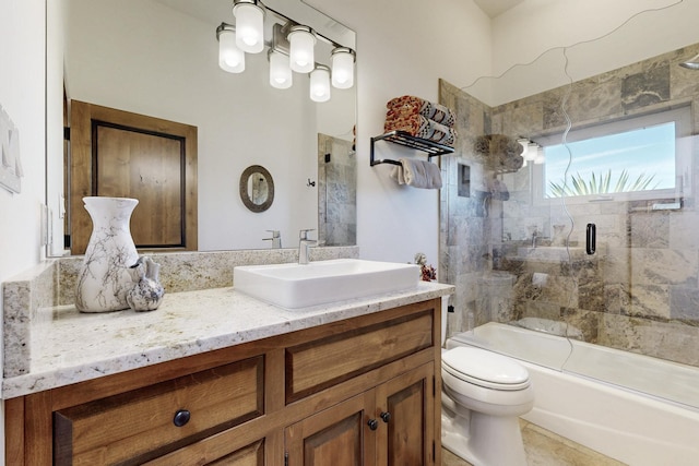 bathroom with vanity, toilet, and bath / shower combo with glass door