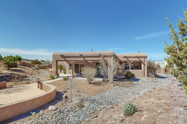 rear view of property featuring a pergola, a patio, and fence