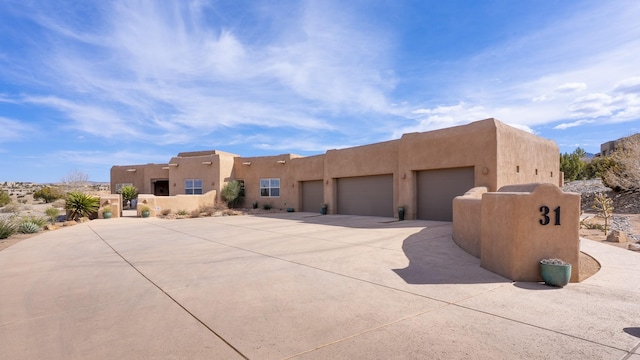 view of front of property with stucco siding, an attached garage, and driveway