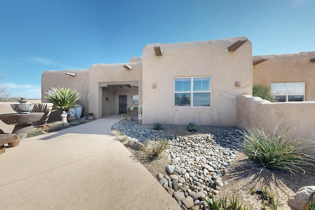 pueblo-style house with stucco siding