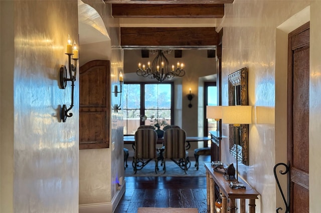 dining space with a chandelier, beamed ceiling, baseboards, and hardwood / wood-style floors