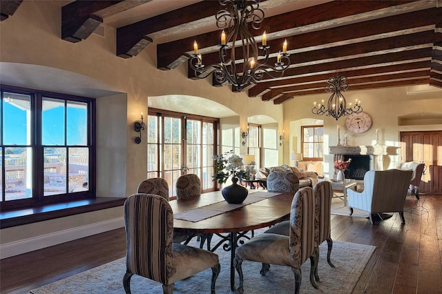 dining space with baseboards, arched walkways, a chandelier, and dark wood finished floors